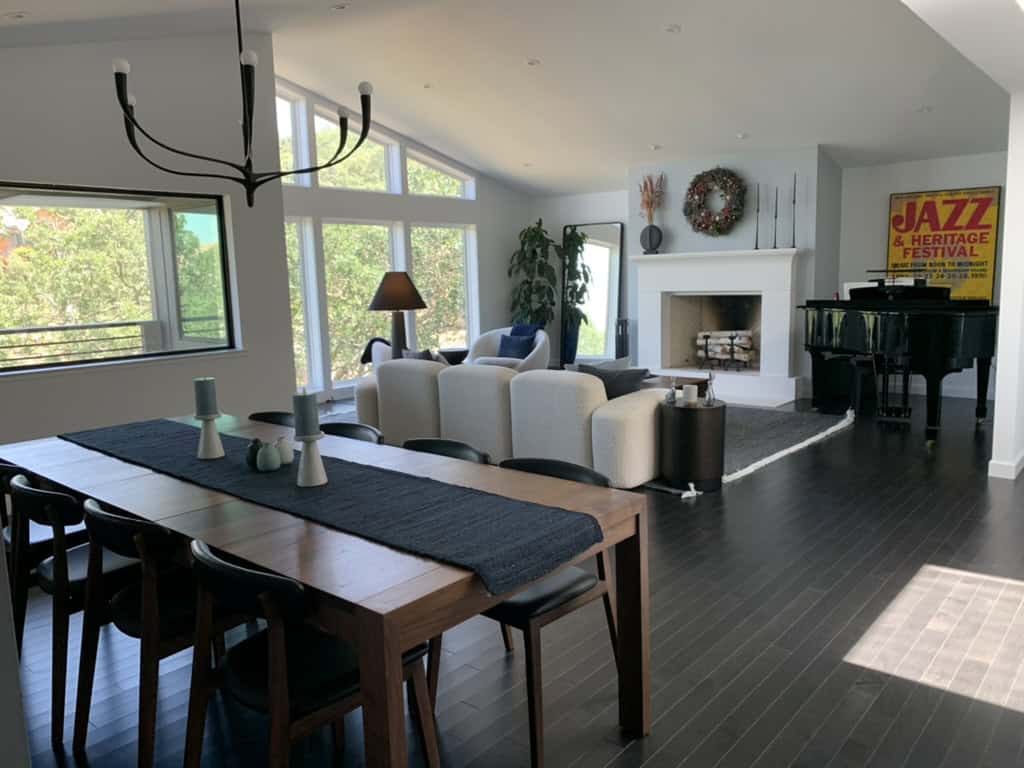 This image shows a bright, spacious living room with a dining table, chairs, sofas, a fireplace, and a grand piano, decorated in a modern style - the completed result of a virtual room makeover with help from design-chat.